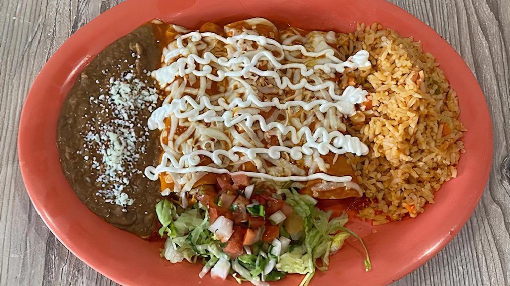 Enchiladas Chx Rojo Sauce · With three rolled corn tortillas with chicken bathed with red sauce and melted mozzarella cheese on top and sour cream at the end with rice and beans.