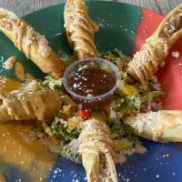 Flautas Appetizer · 6 pieces of Flautas (Fried Rolled up Tortilla stuffed with Chicken and Cheese), On top of Sl...