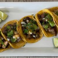 Taqueria Style Taco · The meat of your choice, onions, and cilantro.