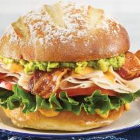 Turkey Avocado Club Sandwich · Potato roll with turkey, bacon, avocado, lettuce, tomato, and roasted tomato spread. Comes w...