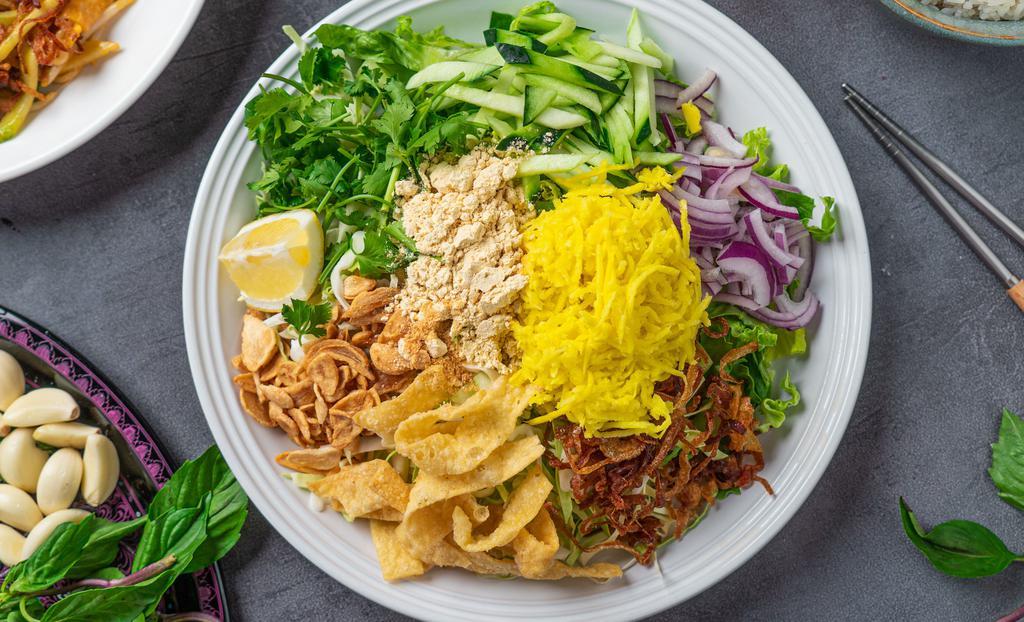 Mango Salad · Pickled mango with fried garlic, cabbage, red onions, cucumber, cilantro, yellow bean powder and fried onions, onion oil and dried shrimp powder on a bed of romaine lettuce. Vegan option available. Gluten-free.