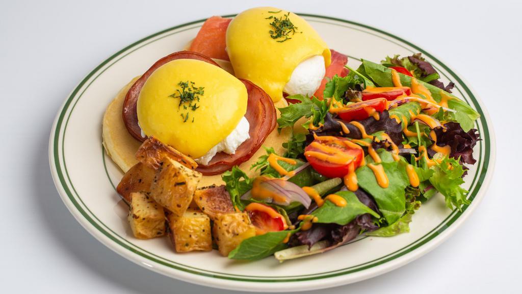 Egg Benedict Pancakes · Wild smoked salmon and Canadian bacon served on pancakes with hollandaise sauce, poached egg, potato, and a side salad.