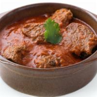 Lamb Curry · Marinated lamb pieces in chef's tomato and onion based curry and topped with spices.