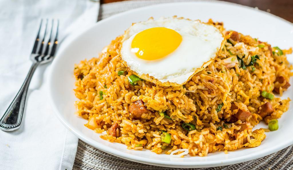 Kimchi Fried Rice · A Korean inspired fried rice sautéed with spicy kimchi, green onions and spam. Topped with cheese and an over easy egg.