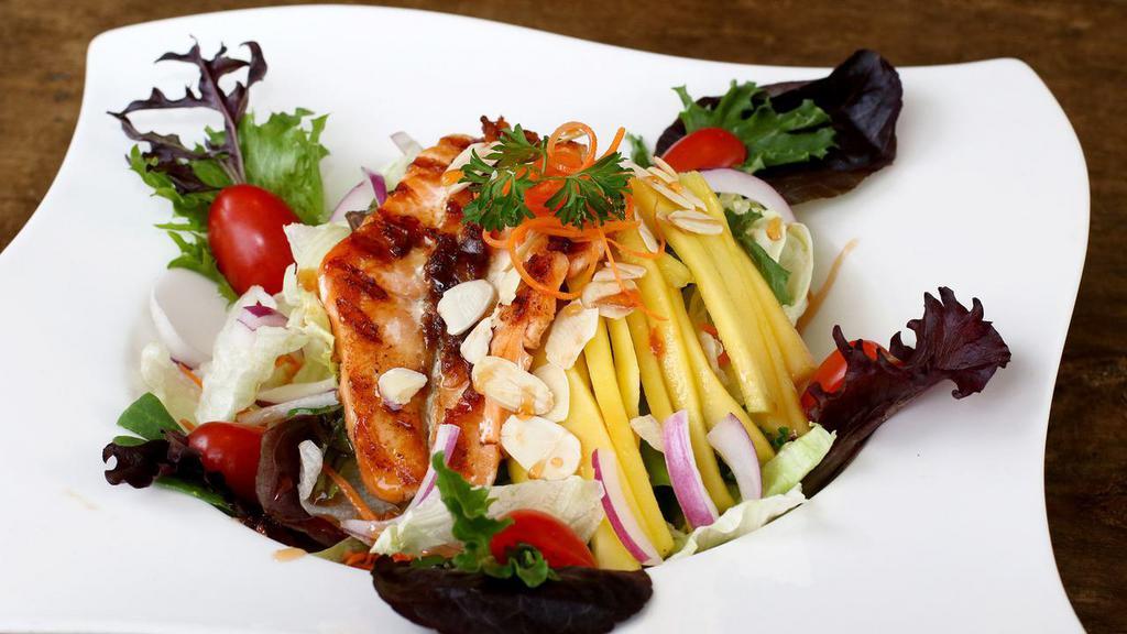 Grilled Salmon Avocado Mango Salad · Gluten-free. Grilled salmon, fresh sliced mango, avocado, fresh garlic, Thai chili red and green onions, mint, grape tomatoes, cilantro and in a spicy lemongrass lime dressing  avocado mango salad.