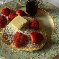 Strawberry Pancakes · 2 large strawberry buttermilk pancakes with butter and syrup.
