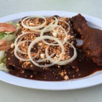 Enmoladas · Rolled-up corn tortilla dipped in red mole sauce filled with cheese, served with a piece of ...