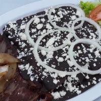 Enfrijoladas · Rolled-up corn tortilla dipped in black beans sauce filled with cheese, served with tasajo (...