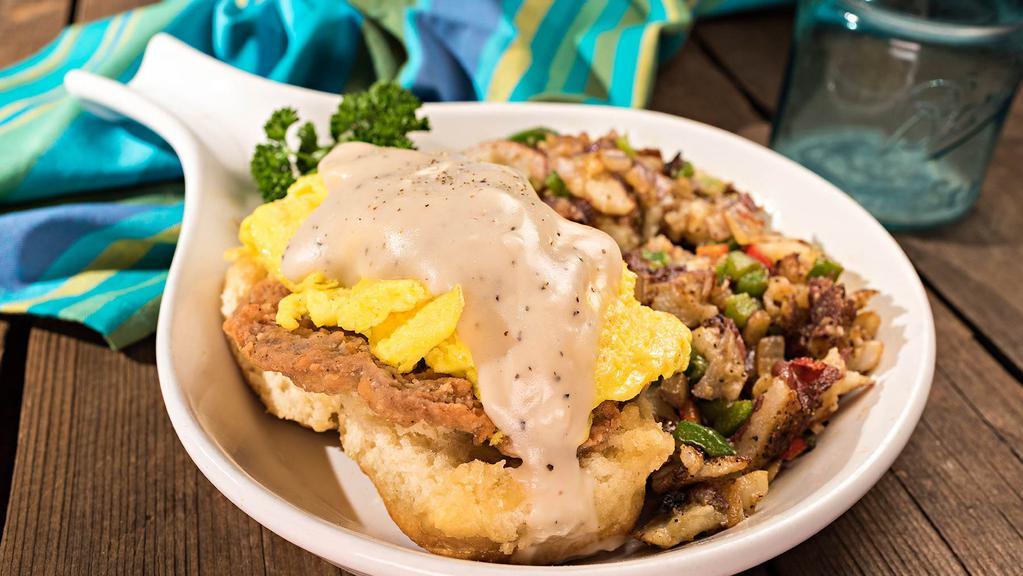 Tom's Scramble · A scratch-made buttermilk biscuit topped with your choice of a sausage patty OR a chicken fried steak, scrambled eggs and Huck's country gravy.  Served with Country Reds or fresh fruit.