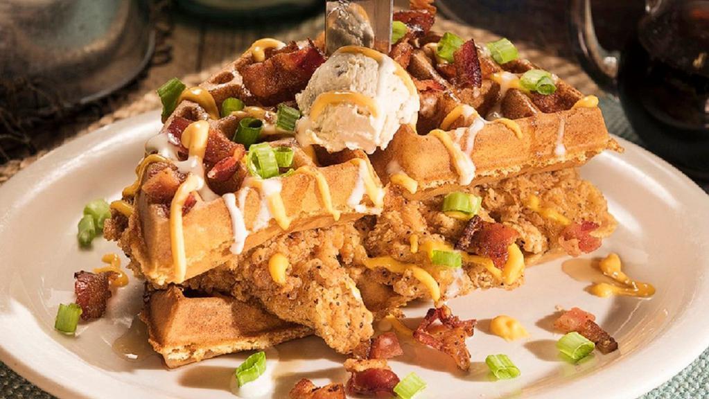 Stacked Chicken and Waffles · A sweet and savory taste explosion!  Two tender hand-breaded chicken breasts between our butter-crisp waffles topped with Sriracha aioli, maple syrup, crisp bacon, green onions and finished with our maple-pecan butter.