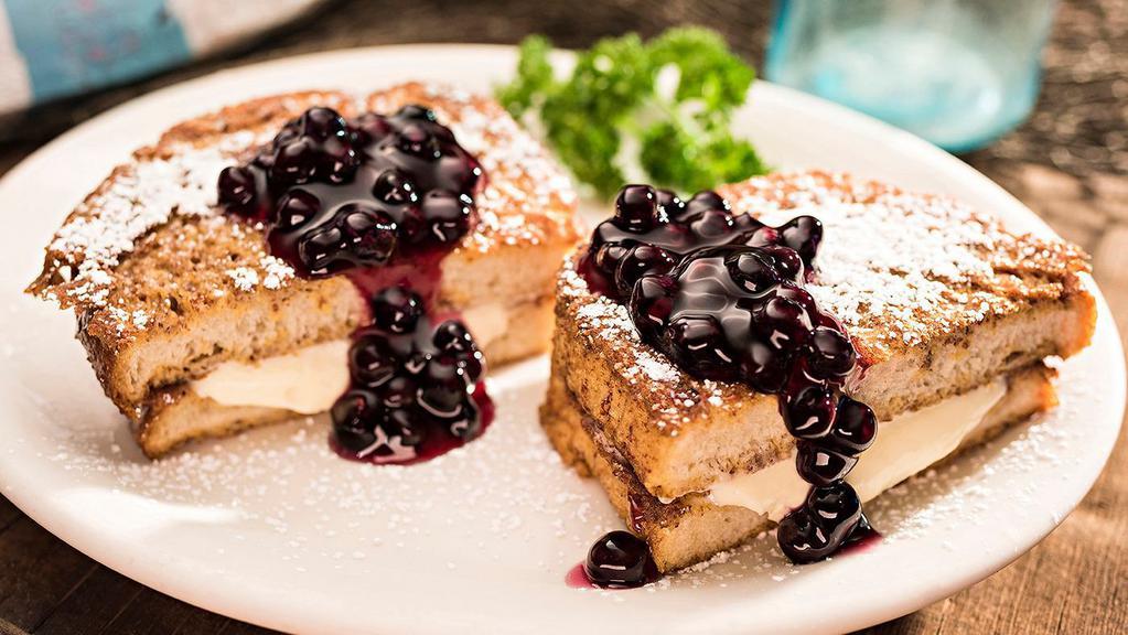 Stuffed French Toast · Two slices of thick New Orleans sourdough, egg dipped & golden grilled then stuffed with sweet vanilla-cream and your choice of fruit topping.