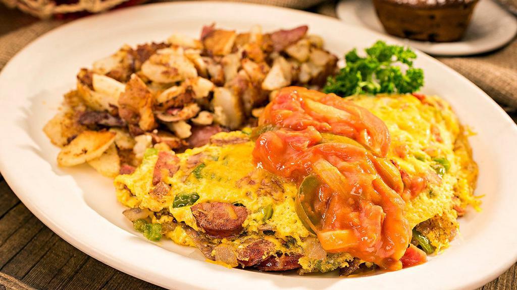 The Cajun Omelet · Andouille sausage, onion, bell pepper & cheddar cheese topped with Creole Sauce.