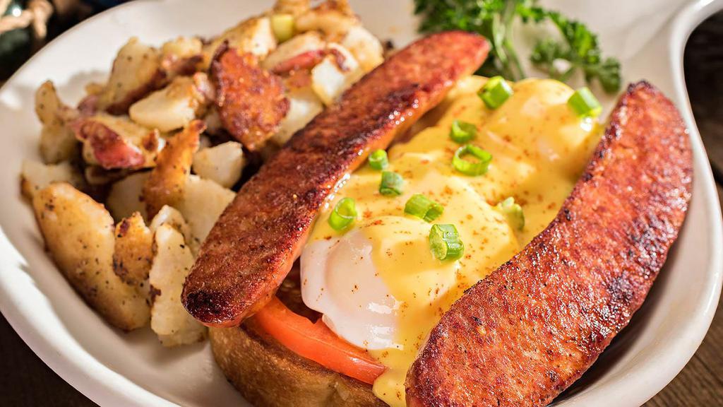 Cajun Benedict · Two poached eggs over grilled andouille sausage, sliced tomatoes and our toasted sourdough topped with green onions.