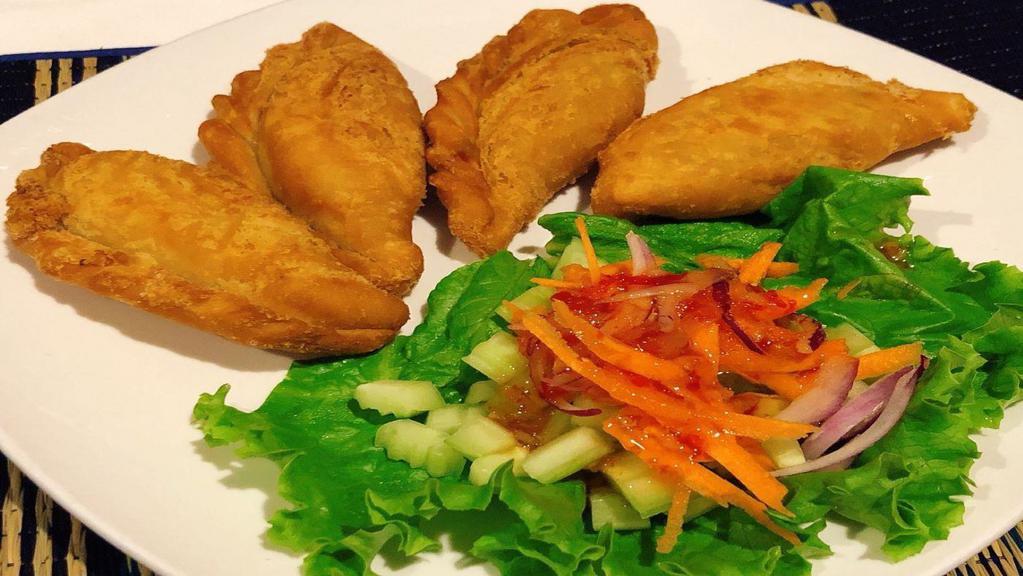 Curry Puffs · Homemade Thai samosa stuffed with yellow curry taro, potatoes, corn, and onion. Served with cucumber salad.