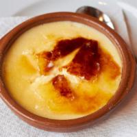 Coppa Catalana Crème Brûlée · Creamy custard topped with caramelized sugar in a glass bowl.