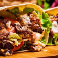 Beef Gyro (Shawarma) Wrap · Savory beef, hummus, lettuce, red cabbage, red onion, tahini, tzatziki, and hot sauce wrappe...