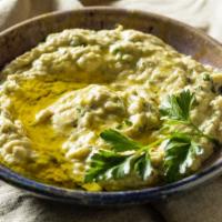 Baba Ghanoush (12oz) · Slow roasted eggplant mashed with traditional spices and served with warm pita bread.