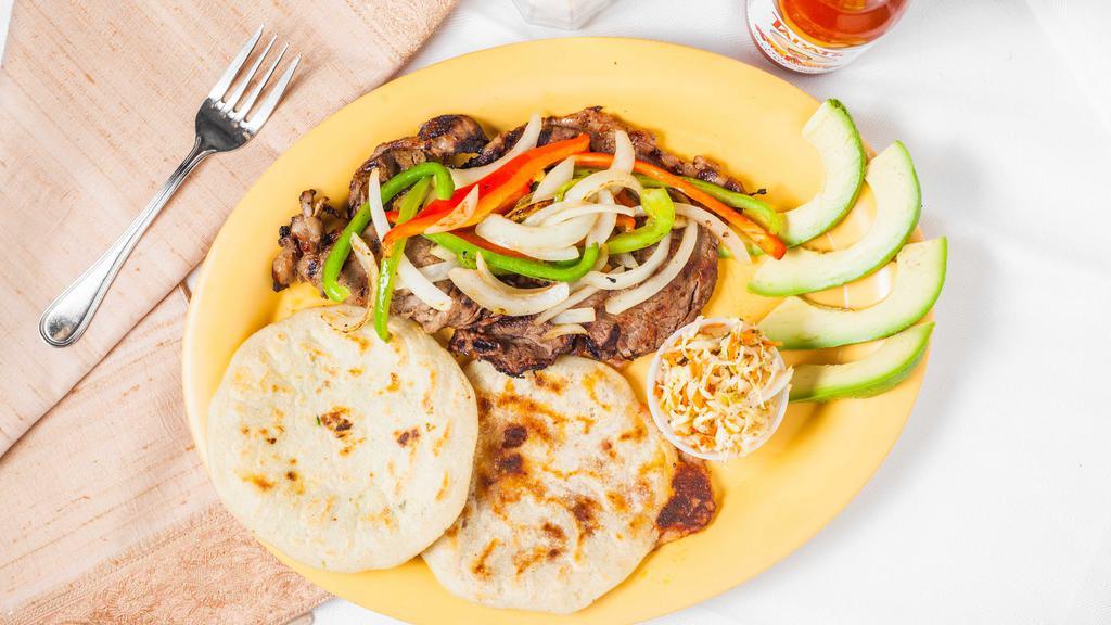 Pupusa Plate · Two pupusas with steak and onions.