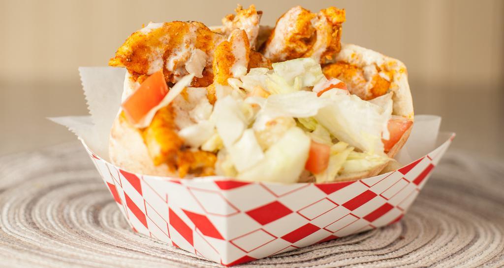 Chicken in a Pita · Tender chicken breast seasoned with spices and topped with lettuce, cucumbers, tomatoes, grilled onions, and tahini sauce.