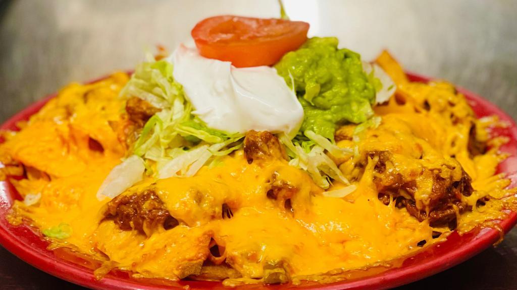 Nachos · Corn chips topped with cheese and mild sauce. Served with guacamole and sour cream.