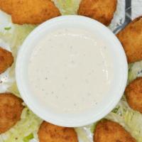 Jalapeño Poppers · Deep fried breaded jalapeño peppers stuffed with cream cheese. Served with pepper cream dres...