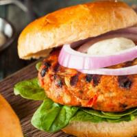 Salmon Burger · Delicious Salmon Burger freshly prepared and cooked to perfection. Topped with lettuce, toma...