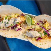 Baja Fish Tacos · two warm flour tortillas, grilled cod, shredded cabbage, house-made creamy jalapeno sauce, s...