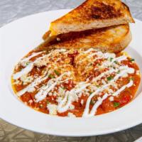 Shakshuka · Two Poached Eggs, Spicy Tomato Sauce, Crema, Roasted Red Peppers, Caramelized Onions, Crumbl...
