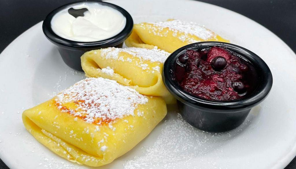 Cheese Blintzes · Three fresh crepes filled with sweet cheese filling, served with warm berry compote & sour cream