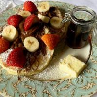 Strawberry Banana Pancakes · 2 large buttermilk pancakes with bananas and strawberries, butter and syrup.