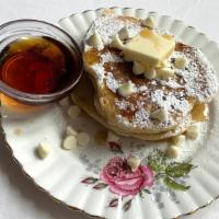 White Chocolate Pancakes · 2 large buttermilk pancakes with white chocolate morsels served with butter and syrup.