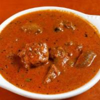 23. Goat Curry · Bone in goat meat cooked in mild spicy caramelized onion sauce.