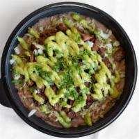 Carne Asada Tazon · a bowl filled with grilled steak, black or pinto beans, rice, onions, cilantro, guacamole an...