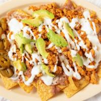 40. SUPER NACHOS · Chips. Beans cheese jalapenos, guacamole sour cream & choice of meat.