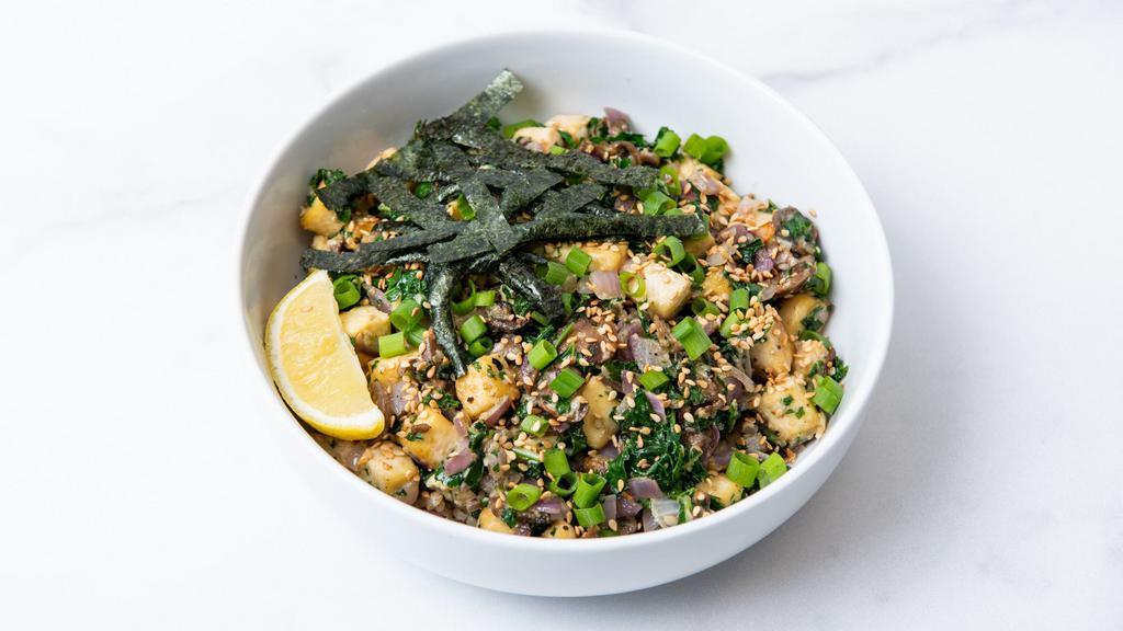 Sesame Surprise · Sesame tofu sauteed with creamy sesame sauce, roasted corn, roasted sweet potatoes, peppers & onions, citrus-marinated kale, green onions, and sesame seeds. Served with a lemon wedge and a base of your choice. (Gluten-free & vegan)