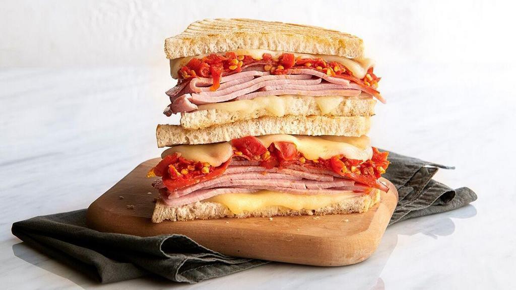 Rustic Italian · pecan wood smoked ham, pepperoni, provolone, oven-roasted tomato, pesto* vinaigrette, spicy Calabrian chili spread, grilled sourdough. *contains nuts