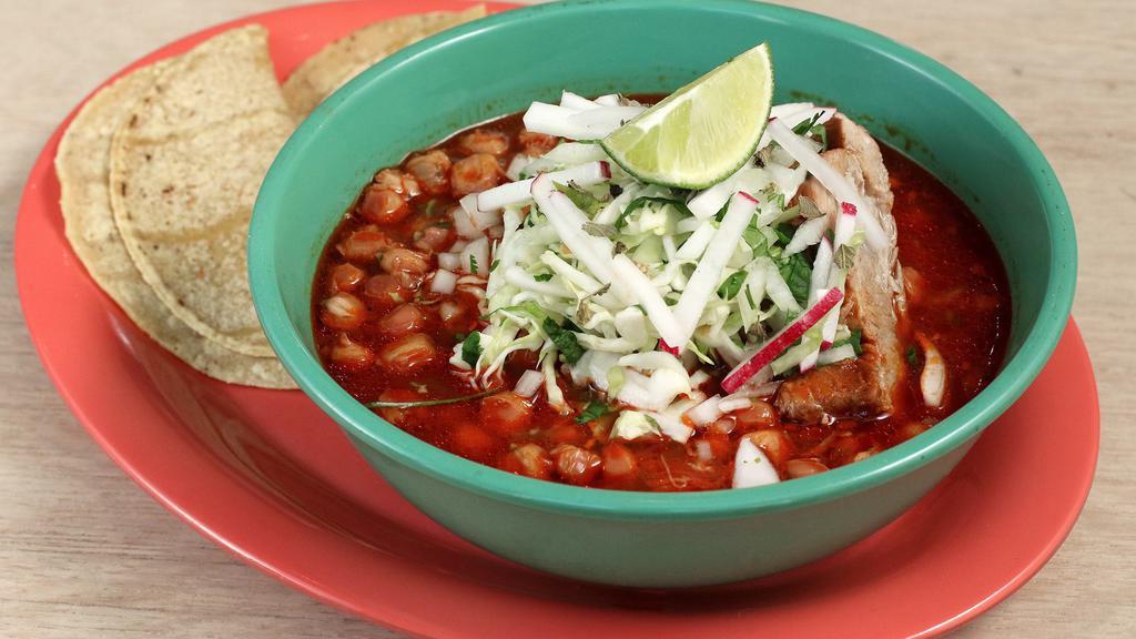 Pozole Rojo · Gluten-free. A pork stew with white hominy, garlic, guajillo chiles, and onions topped with cabbage salad, cilantro and onions and radishes.