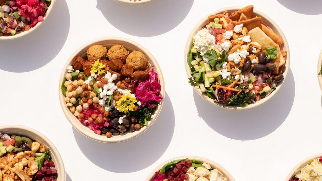 Build Your Own Bowl · Mediterranean spiced couscous and or organic warm chickpeas, with your choice of greens, organic hummus or spread, sustainable protein, unlimited toppings, and 100% vegan sauces.