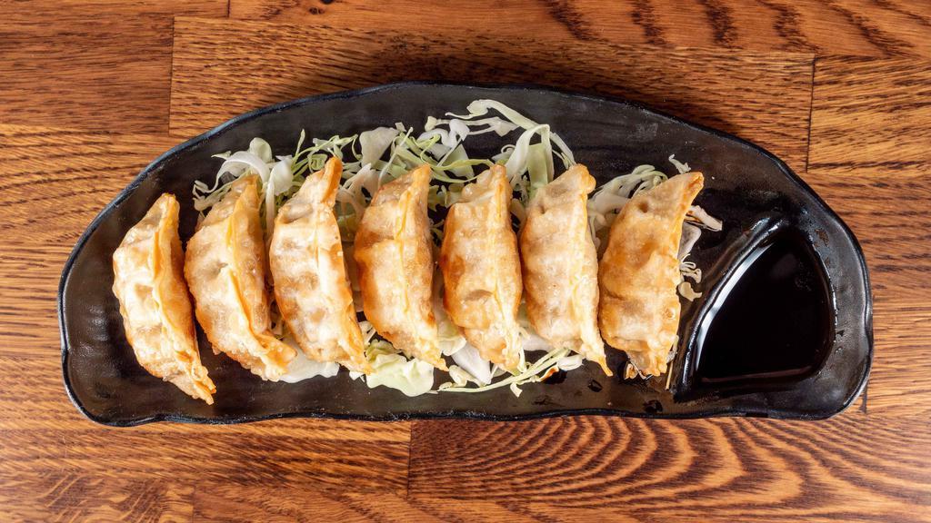 Gyoza (7 Pc) · Deep fried pork potstickers with a side of a soy vinegar and chili oil sauce.