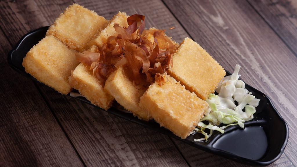 Agedashi Tofu · Drudged in sweet potato flour and fried. Topped with bonito flakes (fish flakes). Accompanied by a side of Tempura Sauce.