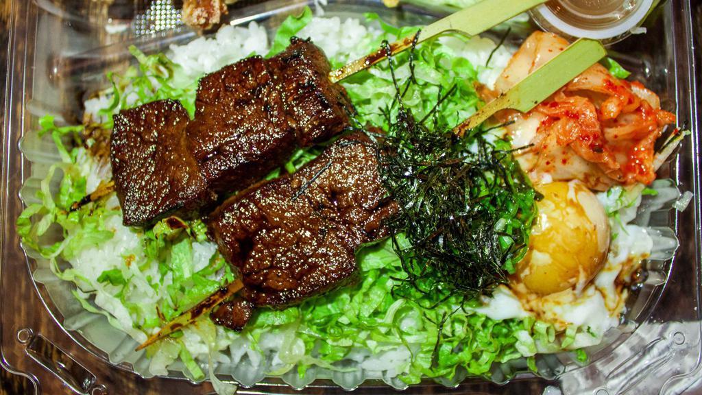 KALBI DON BENTO · 2 skewers of charcoal grilled beef short rib with poached egg, kimchi, green onion, and dry seaweed over rice. Comes with one choice of appetizer and a small salad.