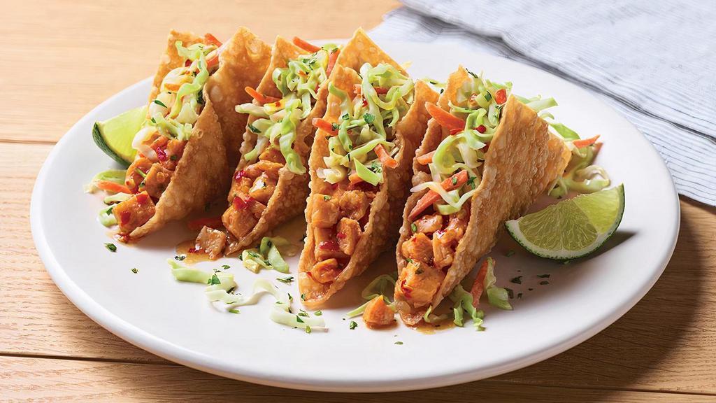Chicken Wonton Tacos · Sweet Asian chile marinated grilled chicken stuffed into crispy wonton shells topped with our signature coleslaw and cilantro.