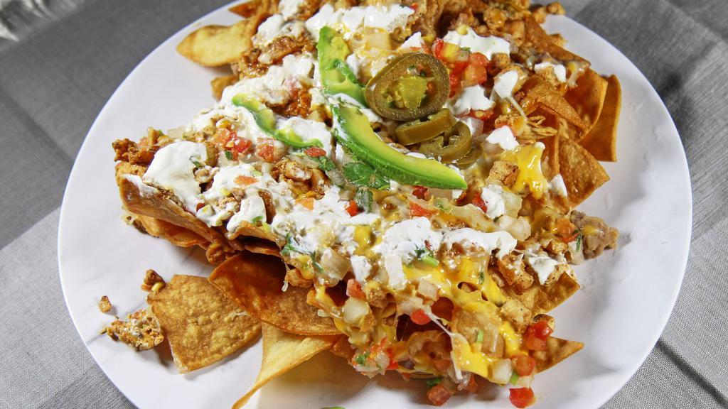 Nachos · Homemade tortilla chips, topped with beans, cheese, sour cream, guacamole and salsa.
