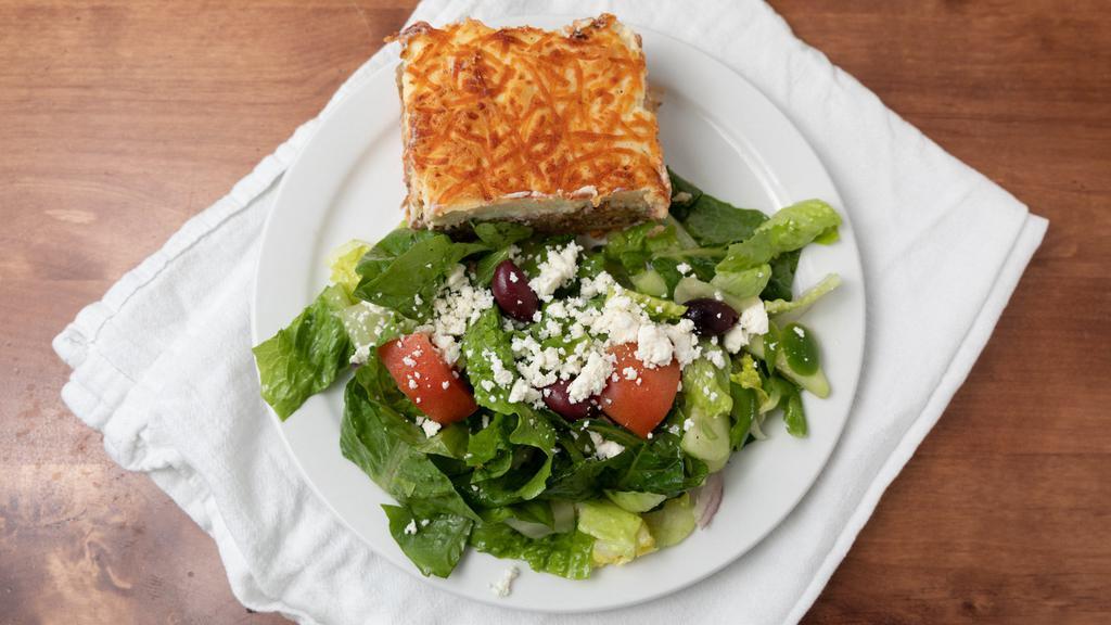 Mousaka · Layered casserole made of potatoes, ground beef and eggplants topped with a cheese-béchamel sauce. Served with a side of the green horiatiki salad.