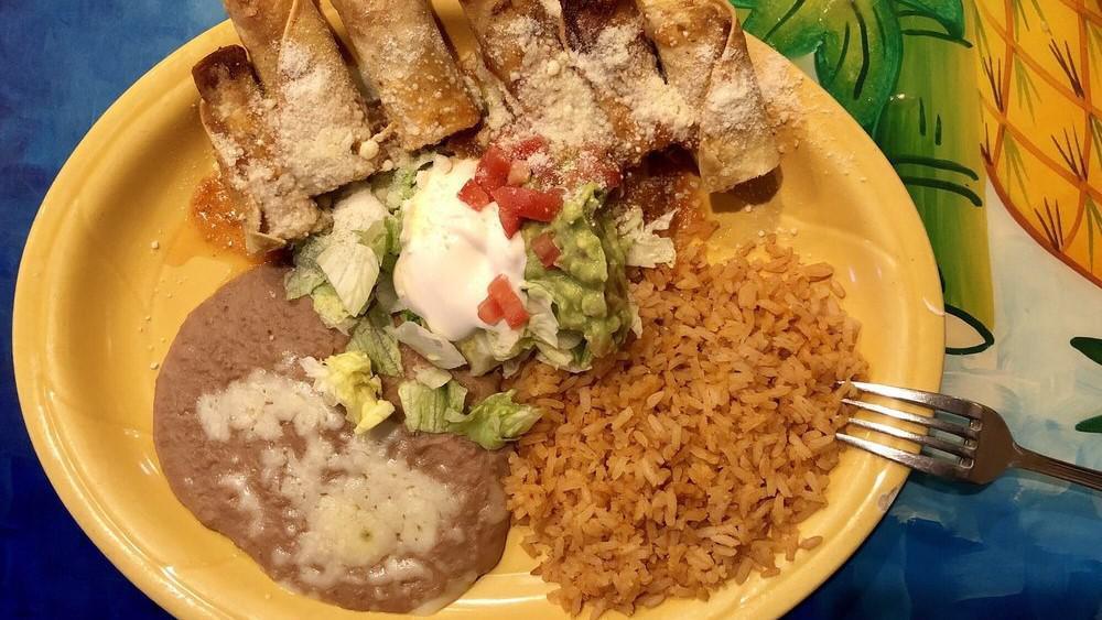 Taquitos Rancheros · Chicken taquitos served with guacamole, sour cream, lettuce, parmesan cheese, rice and beans.