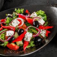 Vegan Greek Salad · Fresh bowl of cucumber, cherry tomatoes, olives, red onions, and vegan cheese.