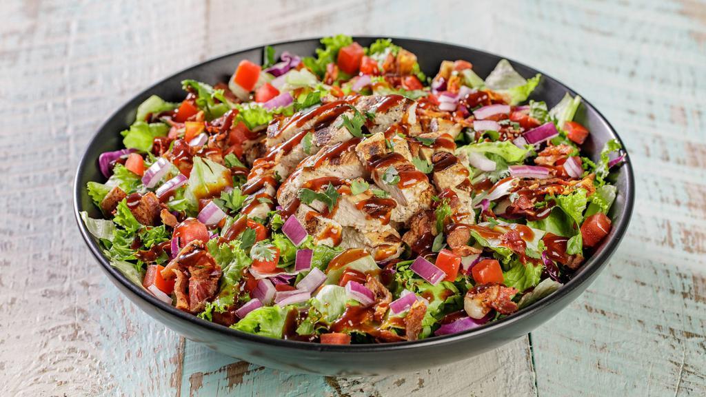 Bbq Chicken Salad · Chargrilled chicken breast atop garden greens, hickory-smoked bacon, diced red onions, diced tomatoes, cilantro, and ranch dressing, topped with tangy BBQ sauce.