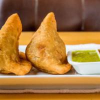 Samosa (2pcs) · Hand crafted indian triangle shaped pastry filled with potatoes, peas and ginger garlic. Ser...