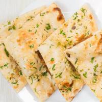 Garlic Naan · Flat bread sprinkled with crushed garlic and baked in tandoor oven.