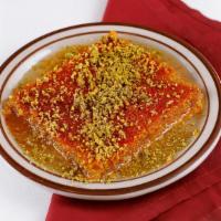 Kunafa · Warm syrup-soaked dessert of shredded wheat and goat cheese topped with crushed pistachio.